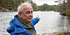 ULYKKESSTADEN: Willy Mjånes peikar utover bukta utanfor Mjåneslendinga ved Storavatnet, der båtulykka skjedde. Borna hadde tenkt seg til ein holme, truleg Vassøyno, for å plukka bær. Då måtte dei i tilfellet ro gjennom sundet i bakgrunnen. Men så langt kom dei ikkje. Willy sin oldefar, Martin Mjånes, var ein av to born som overlevde ulykka. Foto: Einar Vestvik