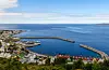 Stortinget vedtok i 1888 at det skulle byggjast ein molo på Alnes på Godøya. Utan moloen hadde det ikkje vore greitt å bu der med Norskehavet ståande rett inn. Frå boka.