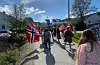 Under steikande sol går de i tog for å feire Noreg.