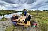 Ein del av dugnadsgjengen samla rundt rastebordet ved Uradalsvatnet. F.v. Ingvar Nymark, Egil Lokna, Sigfrid Olsen, Arild Wiersen (ståande), Torleif Djønne (delvis skjult) og Erling Vallestad.