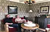 – Me leita ganske lenge etter ein slik raud sofa, men plutseleg ein dag dukka den opp og dét med originalstoffet bevart, fortel Tove Austreim Jacobsen og Bernt Hilmar Jacobsen. Både sofa og bord gjenspeglar 40-tals møblar. Taklampa har tilhøyrt Tove sine besteforeldre på farssida i Haugesund. På veggen Tove sine tippoldeforeldre frå Ulvebne.