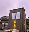 Nybygget er moderne både inne og ute. Store glasflater slepp inn mykje lys til soverommet i andre etasje og stua i første. Foto: Anette Storstein og John Sigfred Stokke