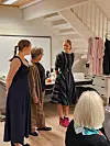 Her viser Anja Leirvik til venstre og Mathilde Haaversen til høgre kjolar frå Hauske Konfeksjon medan Randi Bøe fortel om modellar og stoff.