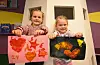 Amanda Dalland Nygård (5) og Selma Halland Tveita (5) viser stolt fram maleriene sine etter høstverkstedet på Sveio folkebibliotek. Foto: Morten Vågset Møller