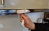 Ein komfyrvakt består av to delar – eit bindeledd mellom komfyren og kontakten, og denne vesle saken som fangar opp om det blir for varmt. Her er også knappen for å få på straumen på komfyren igjen.