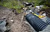 På oppsida av vegen skimtar ein dei gamle betongrøyra i bakgrunnen.
