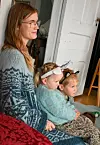 Alfred og Elinor Grutle på mamma sitt fang under lesestunda. Foto: Sigrund Breistig