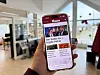 Hand som held ein mobiltelefon med ei lokalavisa Vestavind open på skjermen i eit kontorlokale.