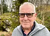 Alf Edvin Hovda poserer utandørs framfor skog og steinar