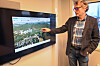 Mann peikar på digitalt kart over Førde på vegskjerm i møterom.