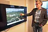 Mann peikar på digitalt kart over Førde på vegskjerm i møterom.