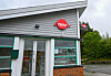Ytre del av Nav-kontor med glasdør og raud Nav-logo på fasaden