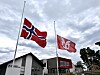 Norsk flagg og Sveio-flagget blafrar på halv stang framfor kommunehuset.