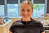 Signe Skjelbreid Myklebust smiler framfor ein kjøkkenbenk med matvarer og utstyr til matpakkebygging.