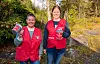 Inger Bente S. Nilsen og Bente Iren Bjørgen i raude aksjonsvestar i skogen.