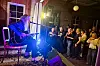 Bjørn Berge spelar gitar på ei lita scene medan publikum følgjer konserten.