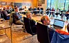 Kommunestyret i Sveio sit samla rundt bord i eit møterom med dokument og datamaskiner.