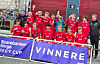Sveio G14-spelarar i raude drakter jublar bak ein banner med teksten «Vinnarar Regy Cup».