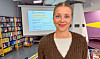 Signe Skjelbreid Myklebust står framfor ein presentasjonsskjerm i eit bibliotek.
