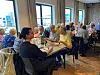 Eldre gjester et komle-middag rundt bord i ein lys restaurant på Edeståvå.