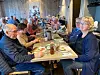 Diners et komle rundt eit langbord i den rustikke matsalen på Edeståvå.