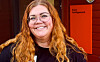 Kristin Bjelland Robberstad smiler framfor inngangen til Sveio Frivilligsentral.