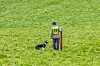 Håkon Rossehaug med hunden Zen på eit grønt grasfelt, iført gul startvest med nummer 19.