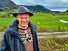 Frode Handeland står framfor grøne jordbruksmarker på Tesdal i Etne.