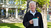 Jan Egeland smiler utandørs medan han held ein kvit kopp.