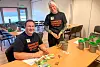 André Mundal Haukås og Kristine Almås tel pengar ved eit bord i eit møterom.