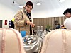 Kvinne ved eit serveringsbord i ein lys kafé, med ein annan person til høgre.