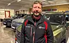 Vegard Nordvik står framfor fleire bilar i utstillingslokalet til Sveio Auto.