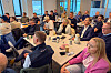 Mange deltakarar sit rundt bord i kantina under B2B Connect-arrangementet på Ekrene.